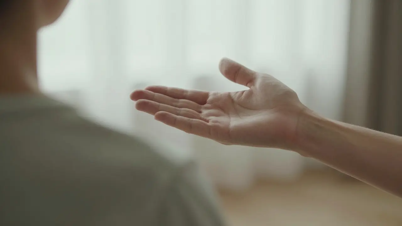Hands hovering gently to sense energy in a safe, lit room